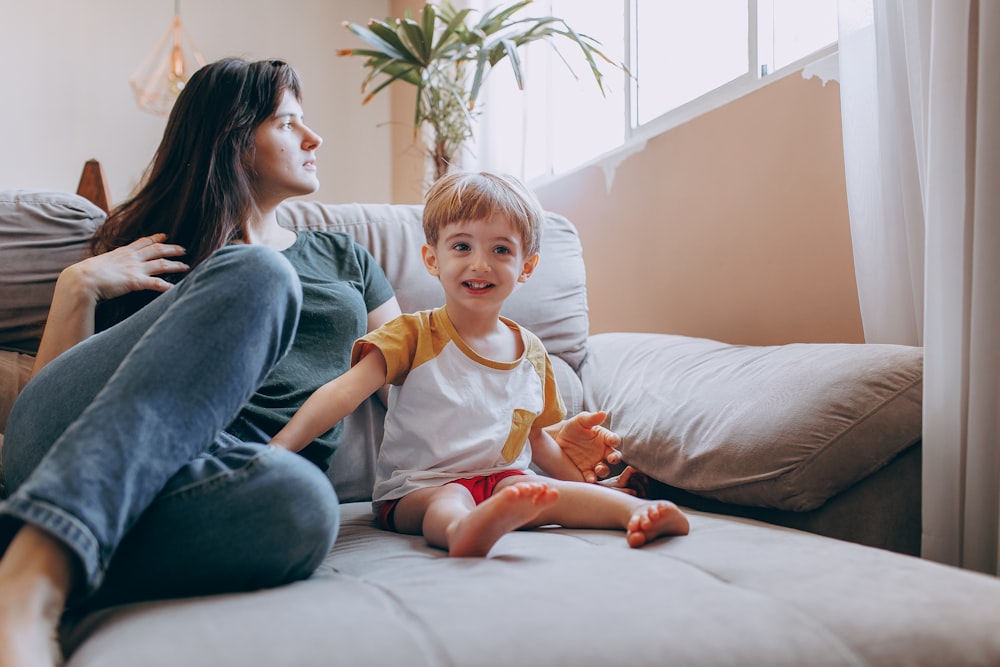 a woman and a child sitting on a couch