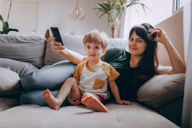 A happy family relaxing comfortably in their smart-enabled home with subtle tech devices visible.