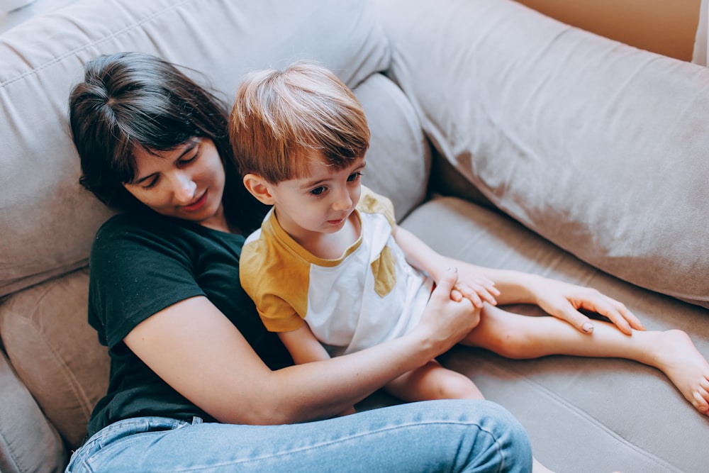 a woman and a child sitting on a couch