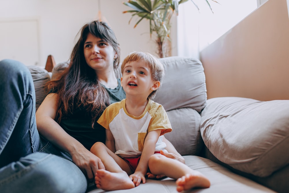 a woman and a child sitting on a couch