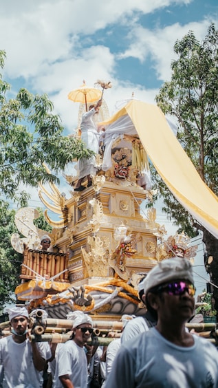 a group of people walking down a street next to a statue