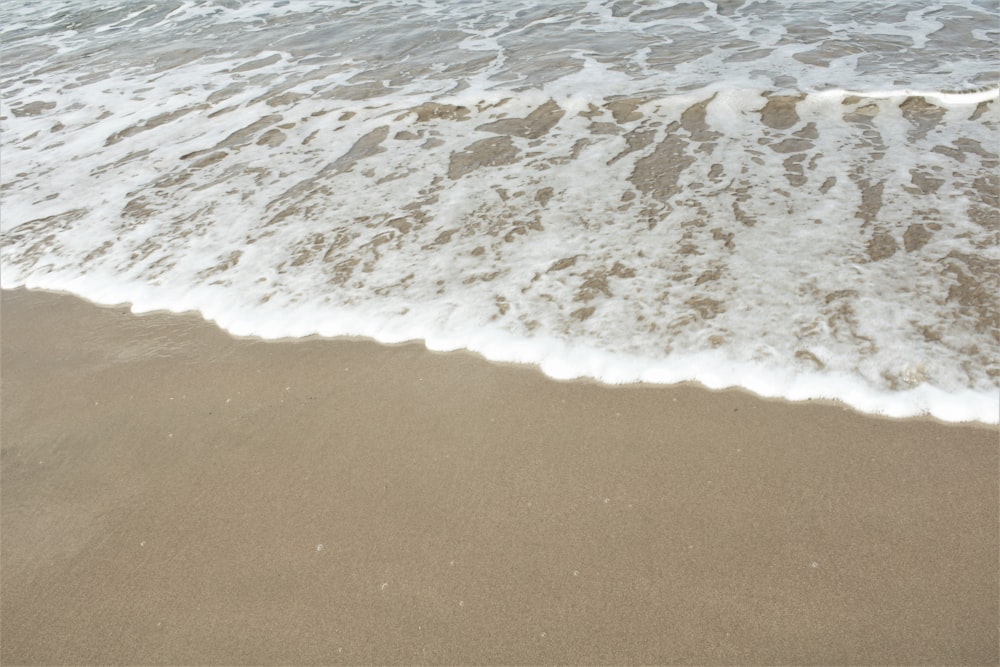 a beach with a wave coming in to shore