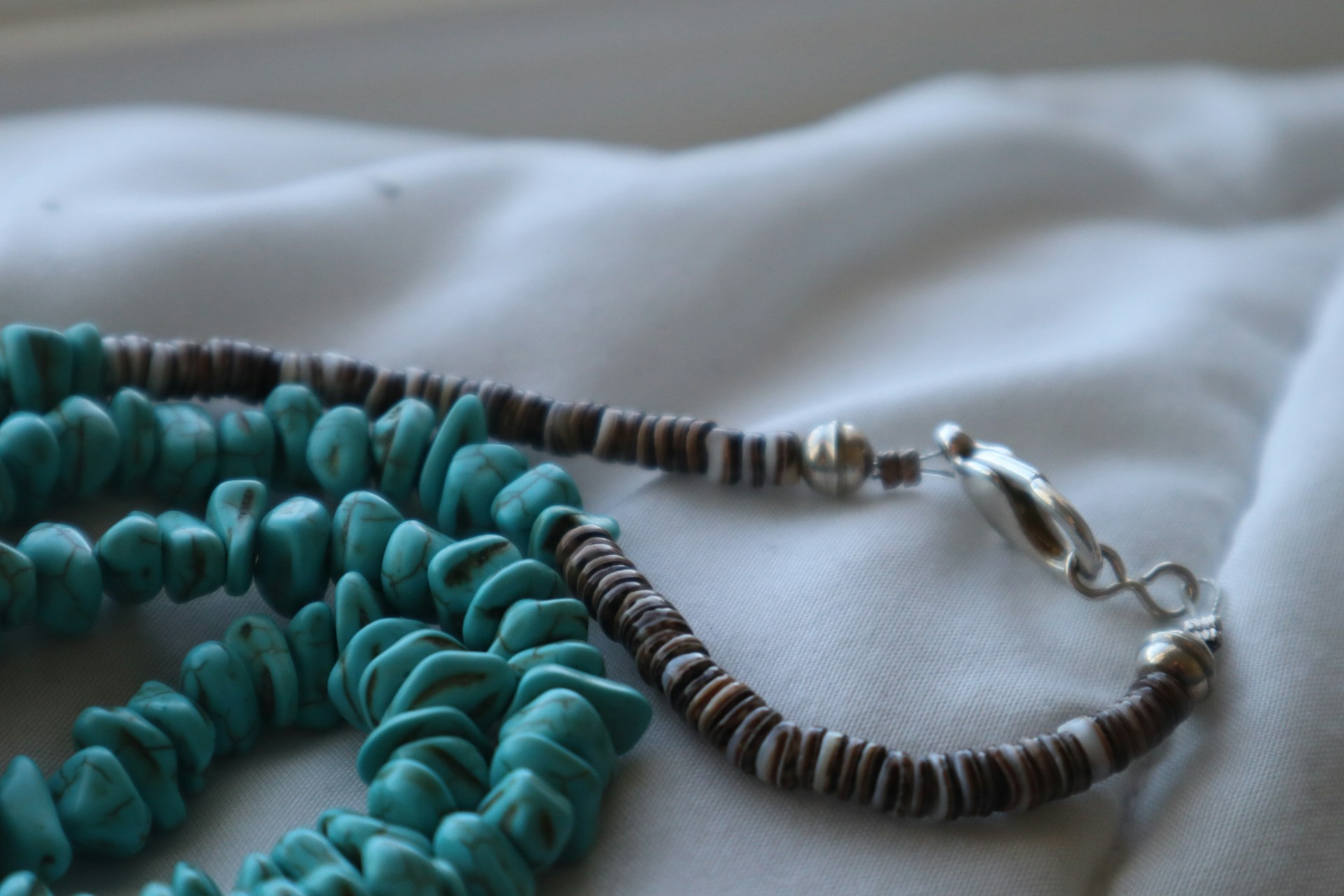 a close up of a necklace on a bed