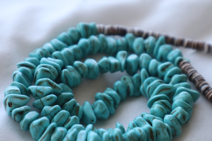 a close up of a necklace on a white surface