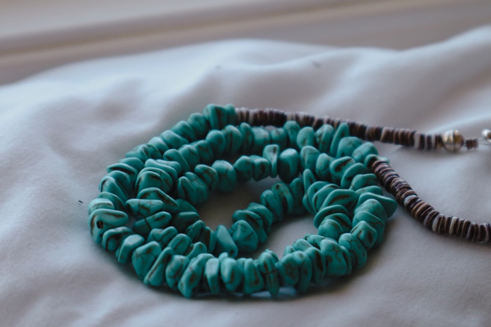 a beaded necklace is laying on a bed