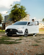 a man sitting inside of a white sports car