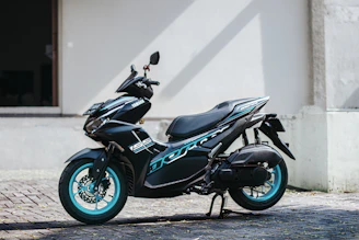 a black and blue motorcycle parked in front of a building