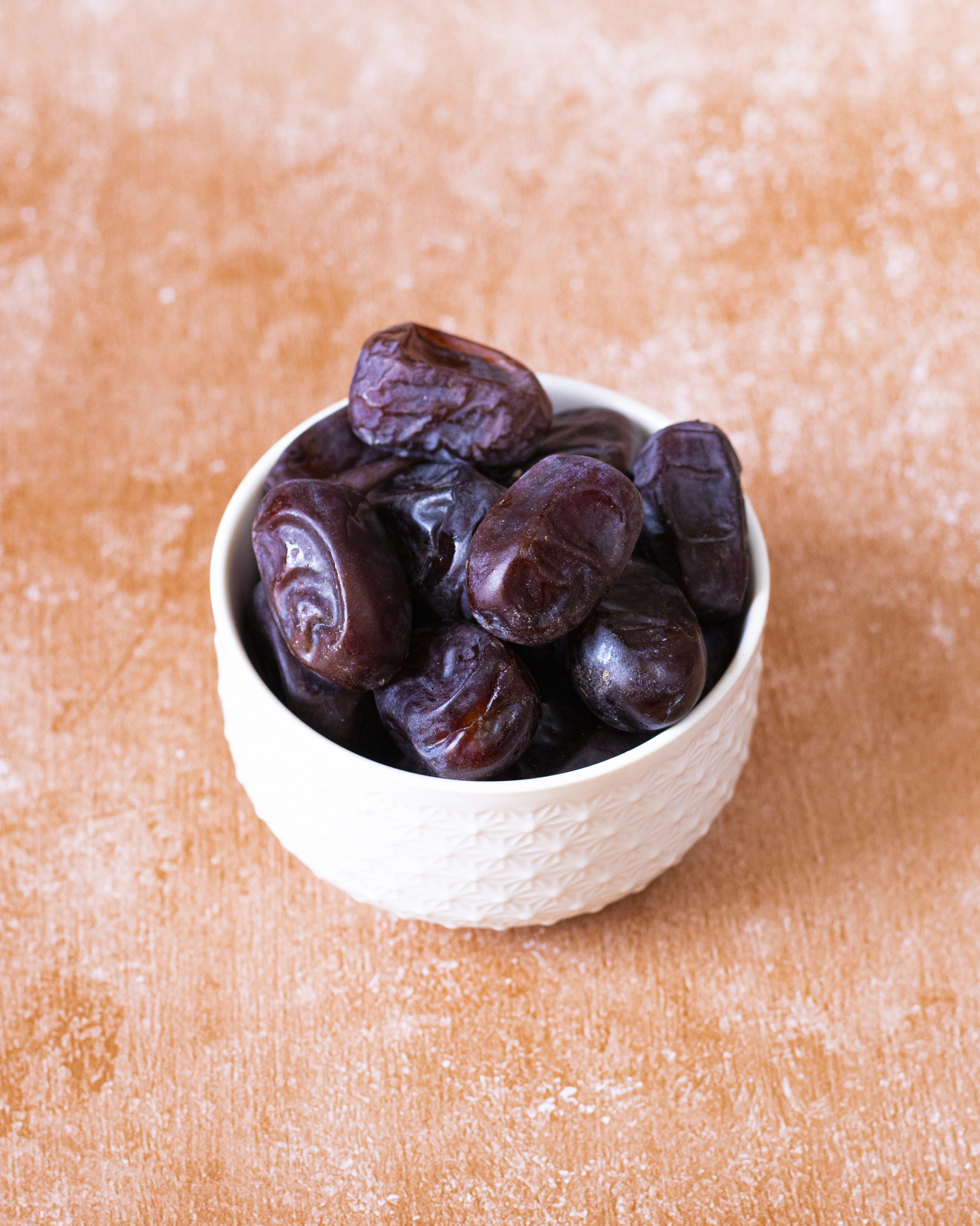 Kurma berwarna gelap dalam mangkuk putih