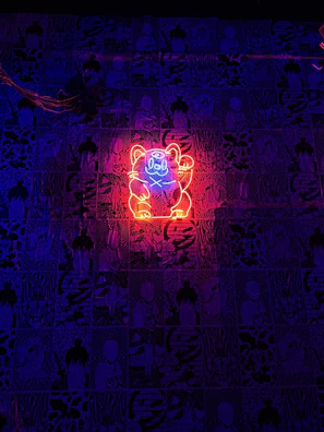 Four stylized beatnik cartoon cats logo illuminated on a DJ booth backdrop.