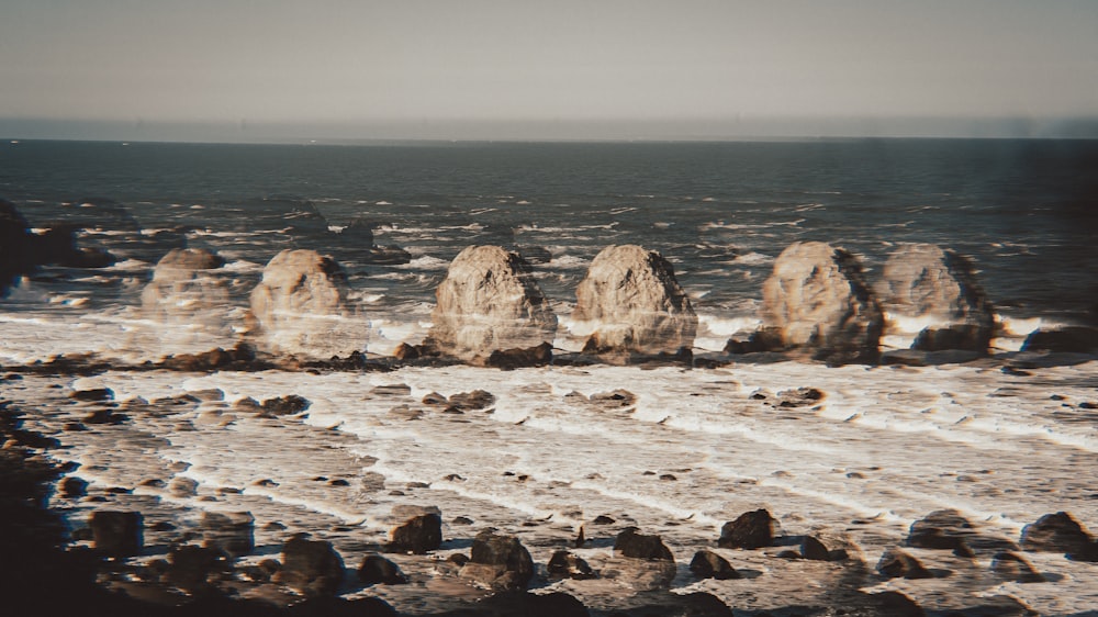 a group of rocks sitting on top of a sandy beach