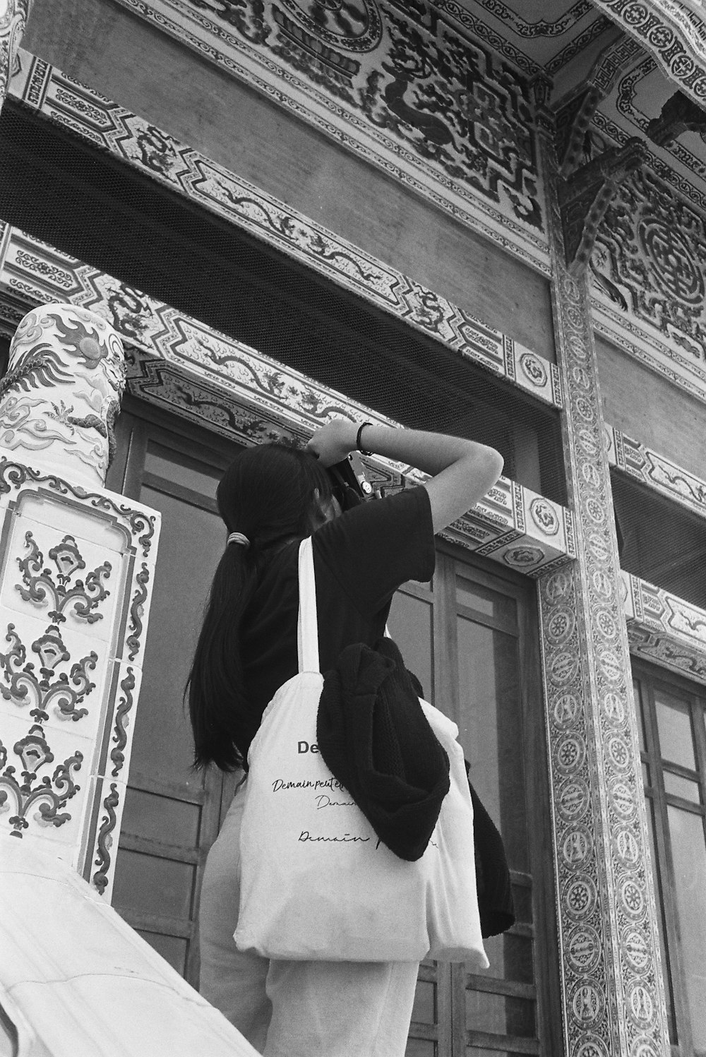 a black and white photo of a woman carrying a bag