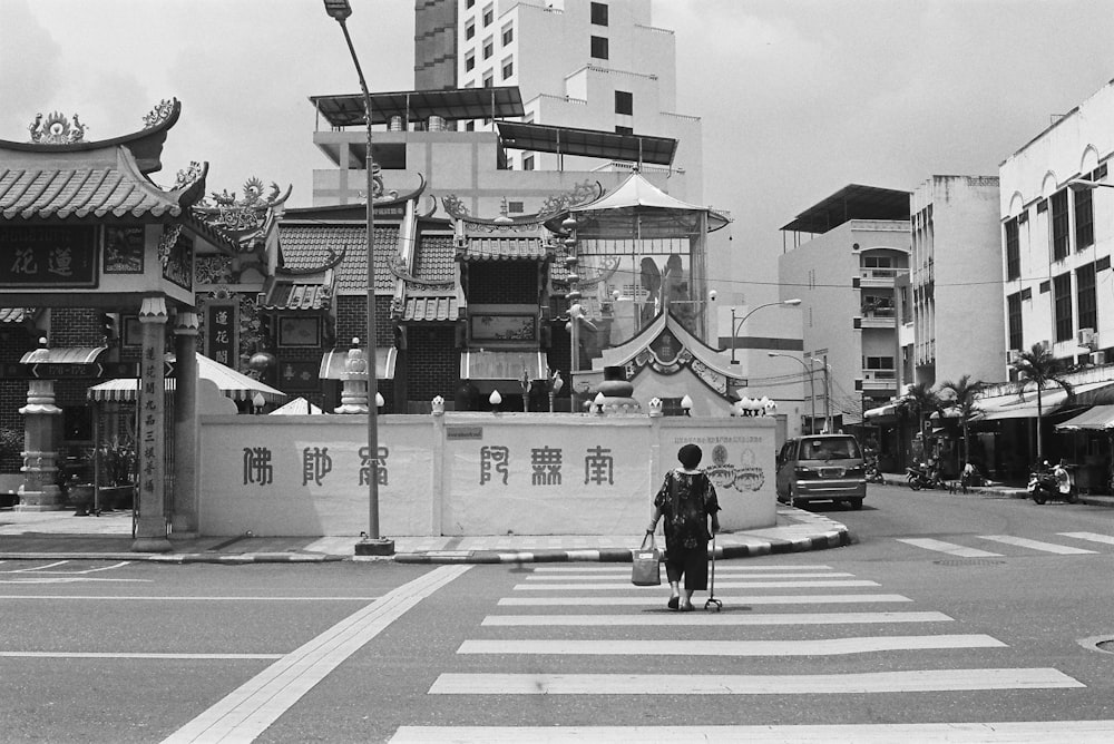 a person crossing a street in front of a building