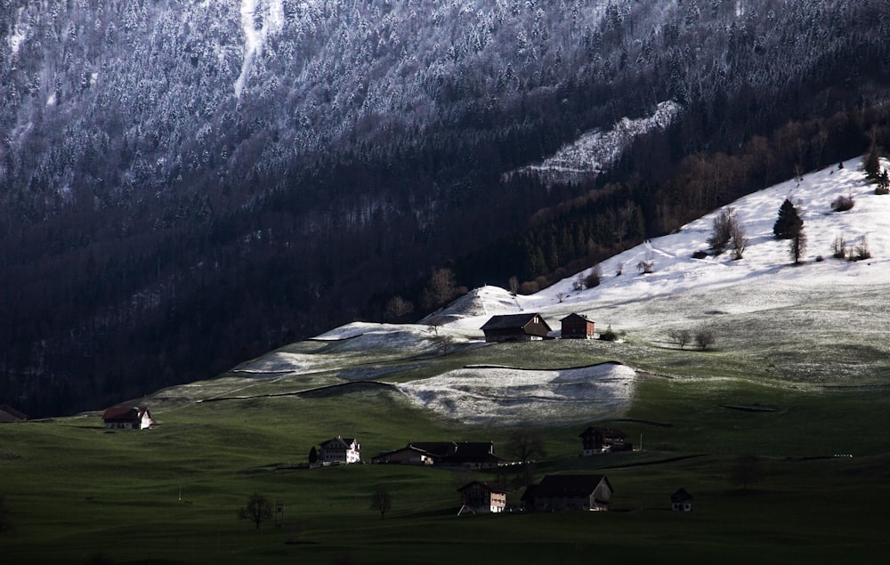 a snow covered mountain with a small village in the foreground