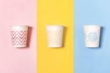 three different colored cups with designs on them