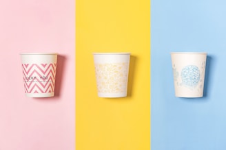 three different colored cups with designs on them