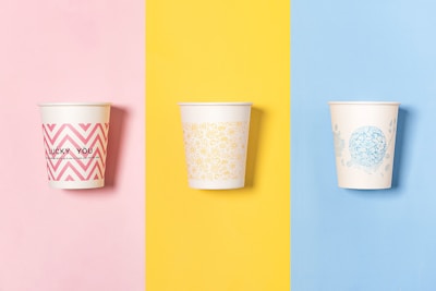 three different colored cups with designs on them