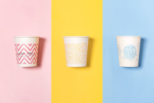 three different colored cups with designs on them