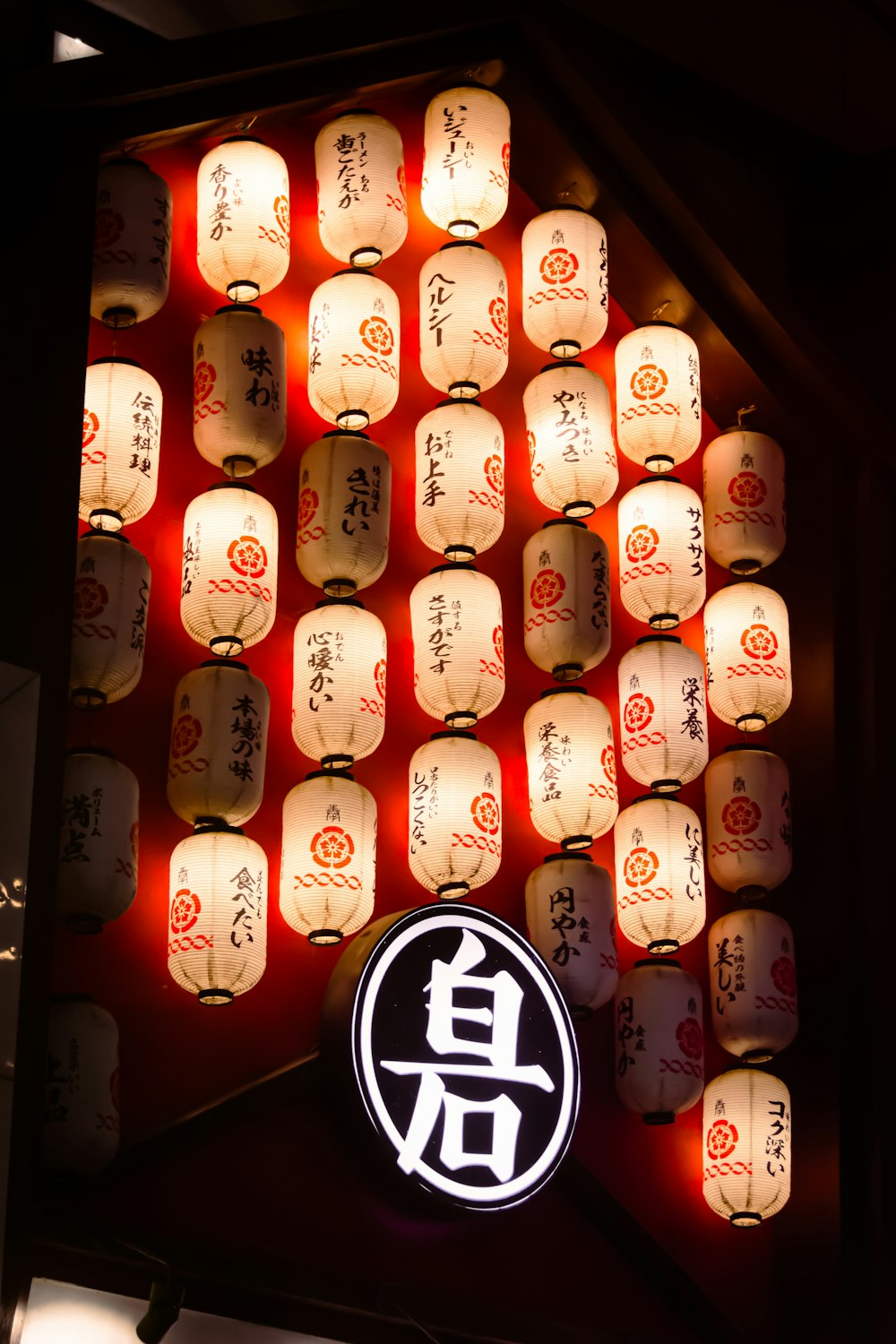 a large display of paper lanterns with asian writing on them