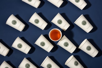a cup of tea surrounded by many cups