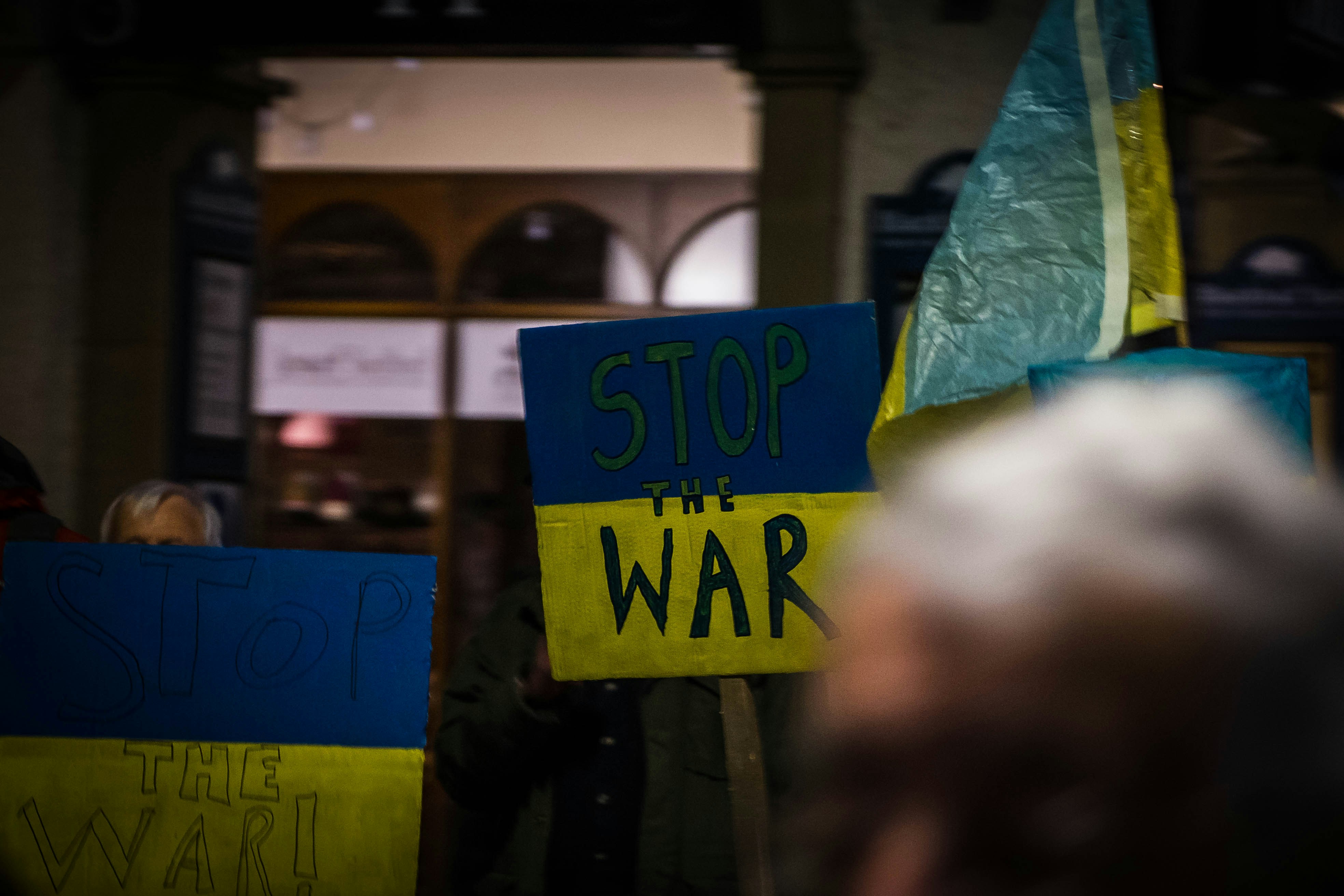 a group of people holding signs that read stop the war
