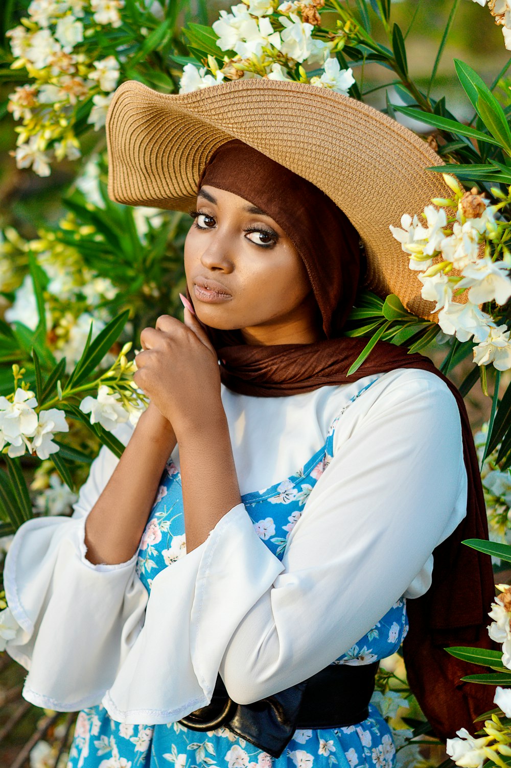 a woman wearing a straw hat and a blue dress