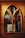 A wooden cabinet with an arched glass door reveals several books stacked inside. Prominent titles include works by Paul Coelho and National Geographic. The warm wood tones of the cabinet contribute to a cozy and inviting ambiance.