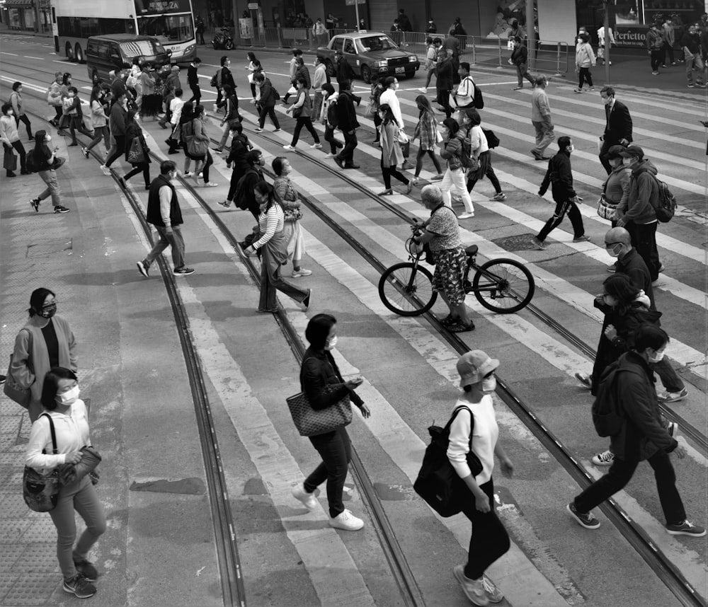 a black and white photo of people crossing a street