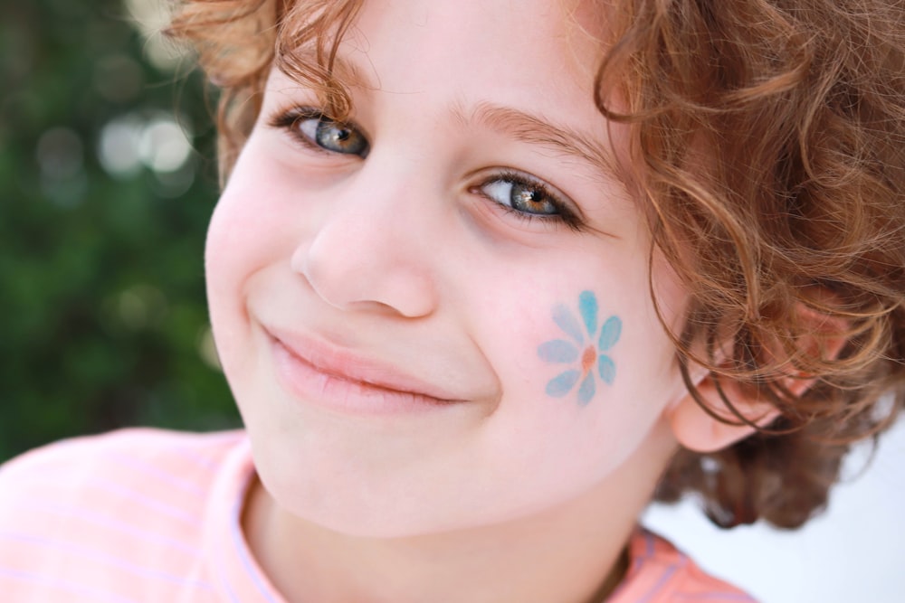 a little girl with a flower painted on her face