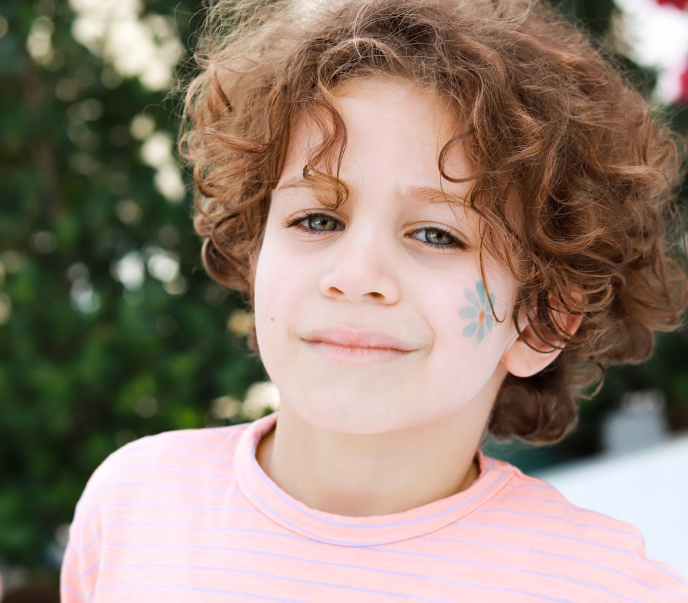 a little girl with her face painted with flowers