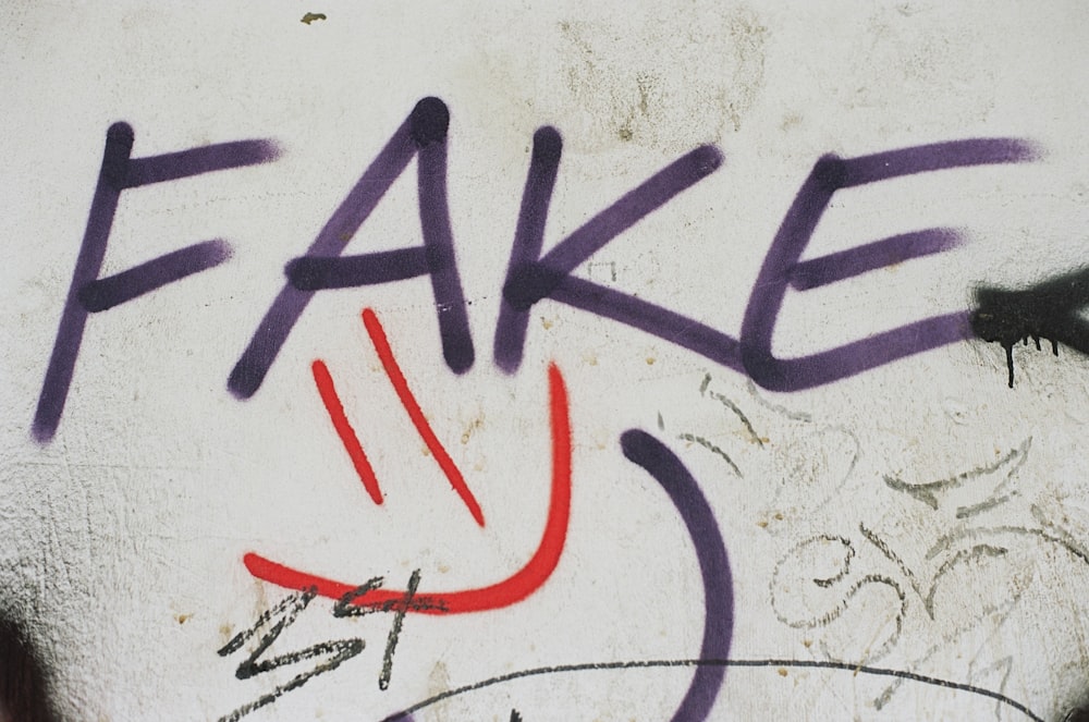 graffiti on a wall that says fake