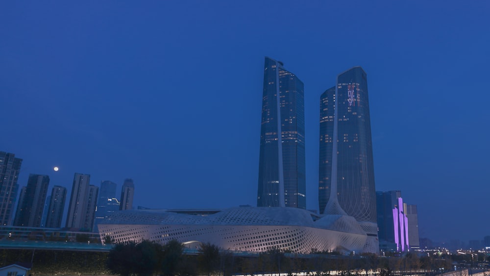 a city skyline at night with tall buildings in the background