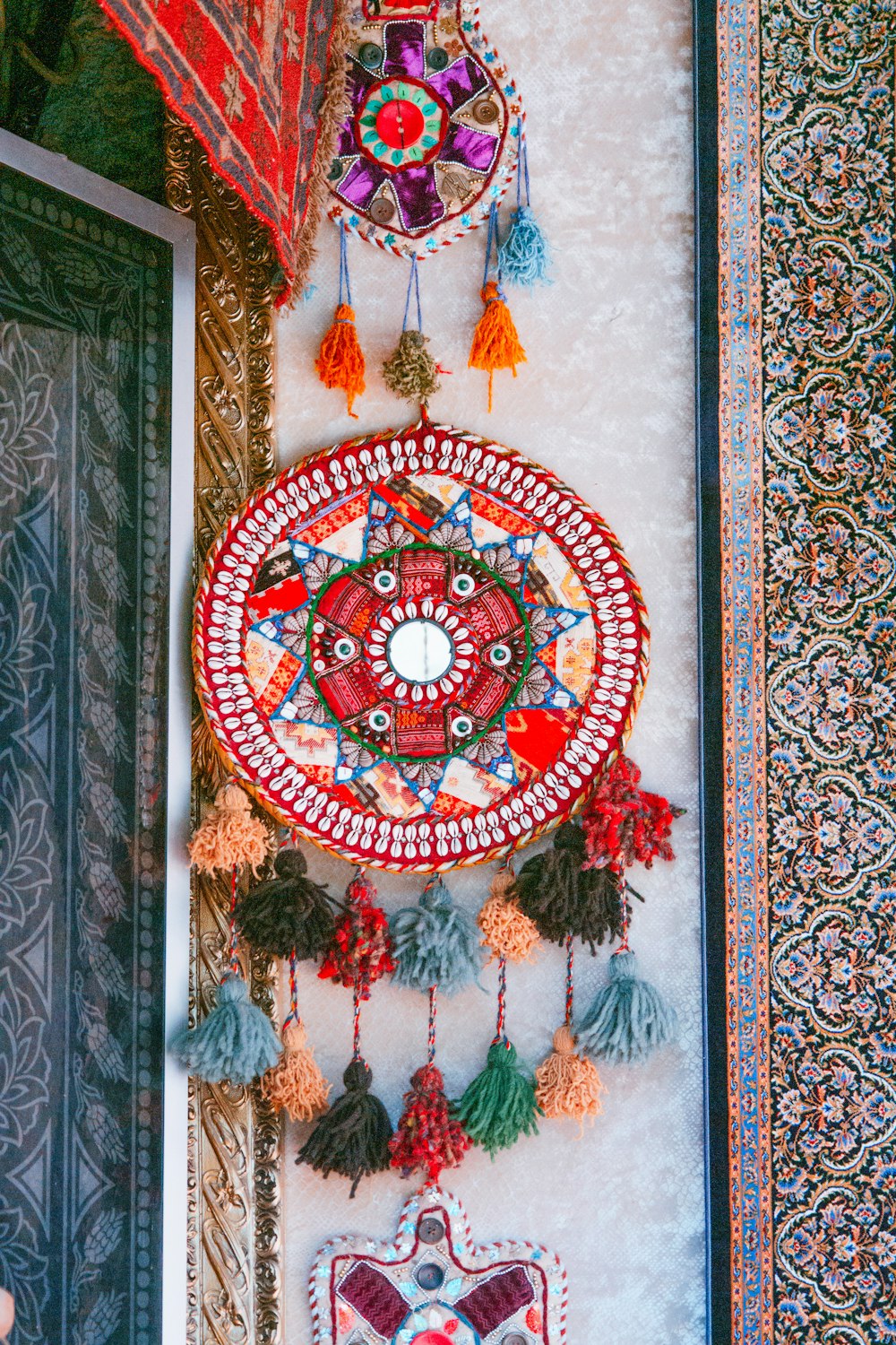 a decorative wall hanging with a mirror and tassels