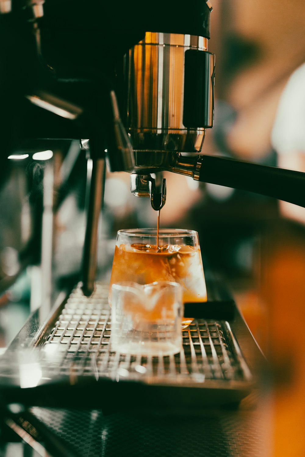 a glass filled with liquid being poured into a cup