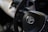 A close-up view of a car's steering wheel with a prominent Toyota logo in the center. The background is slightly blurred, focusing attention on the steering wheel and logo.