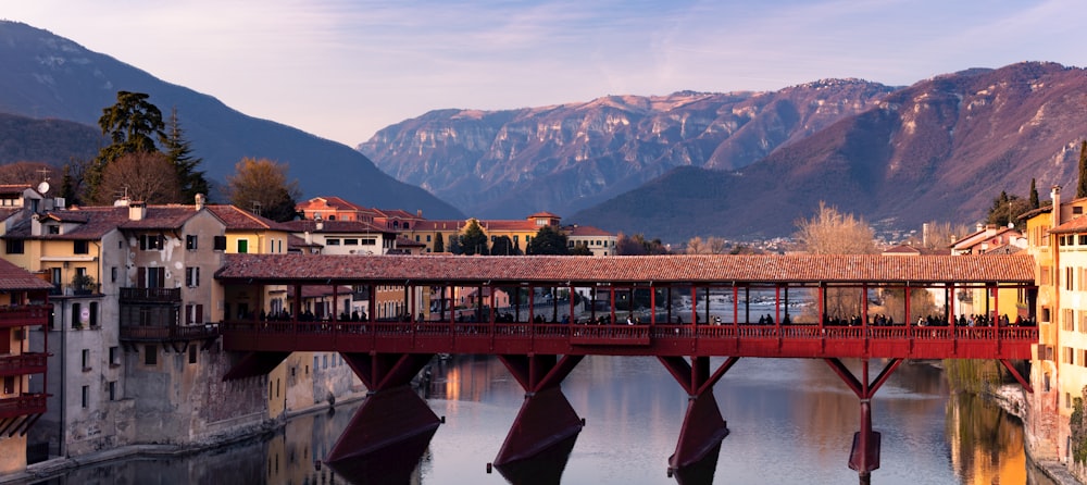 a bridge over a body of water with mountains in the background