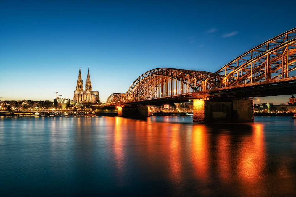 a bridge over a body of water with a city in the background