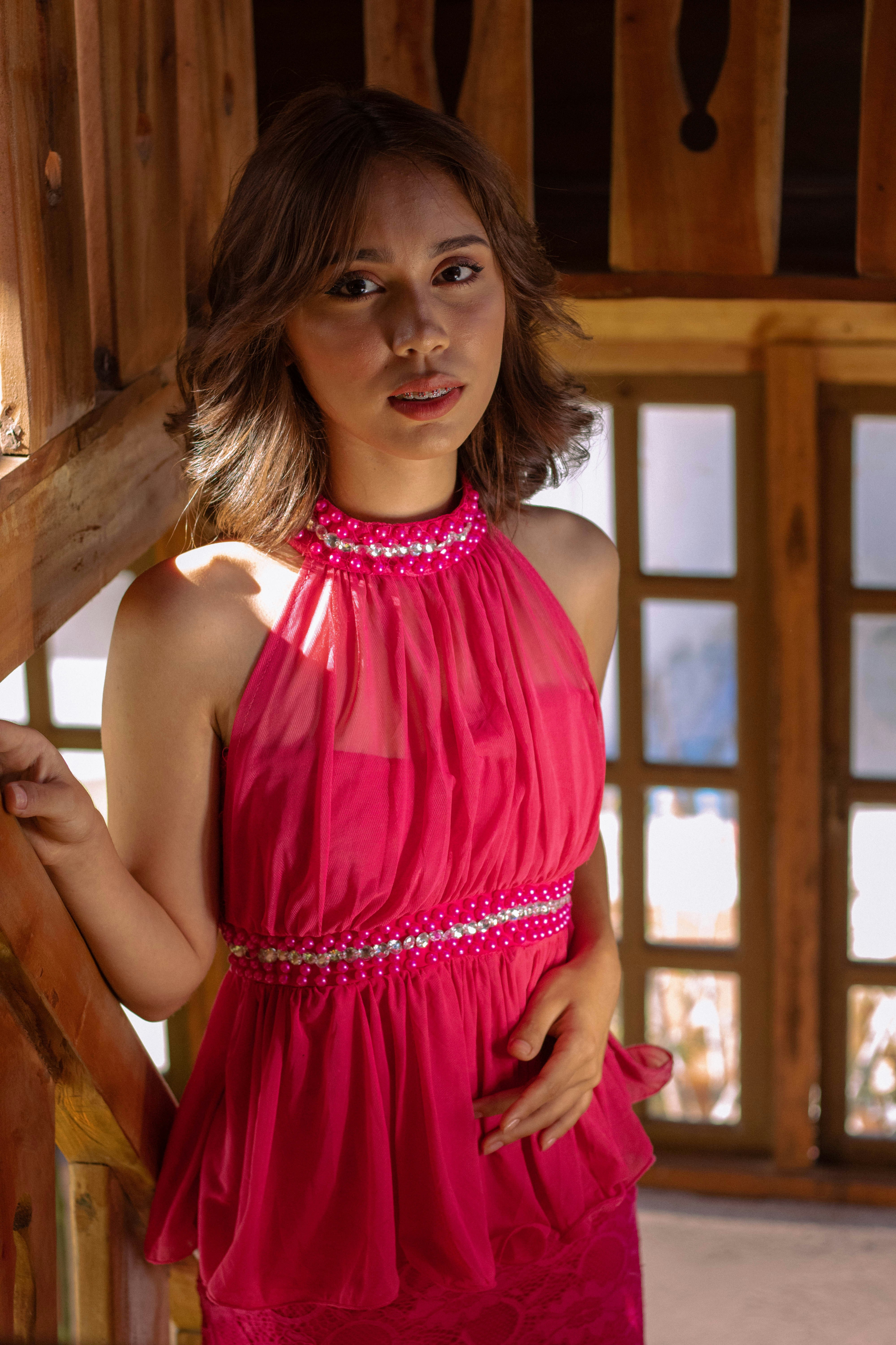 a woman in a pink dress posing for a picture