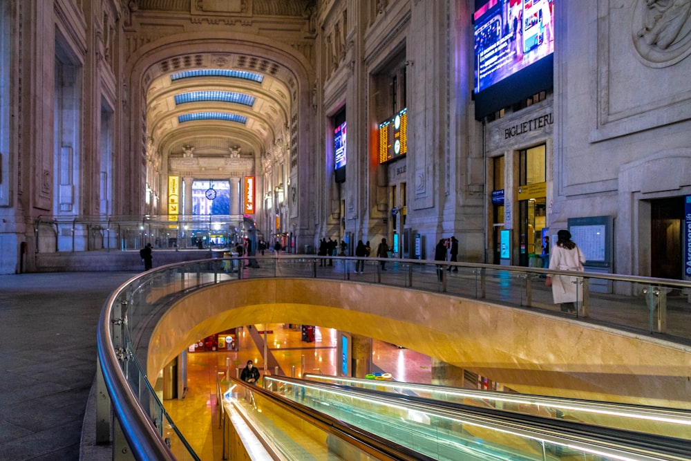 an escalator in a large building with people walking around