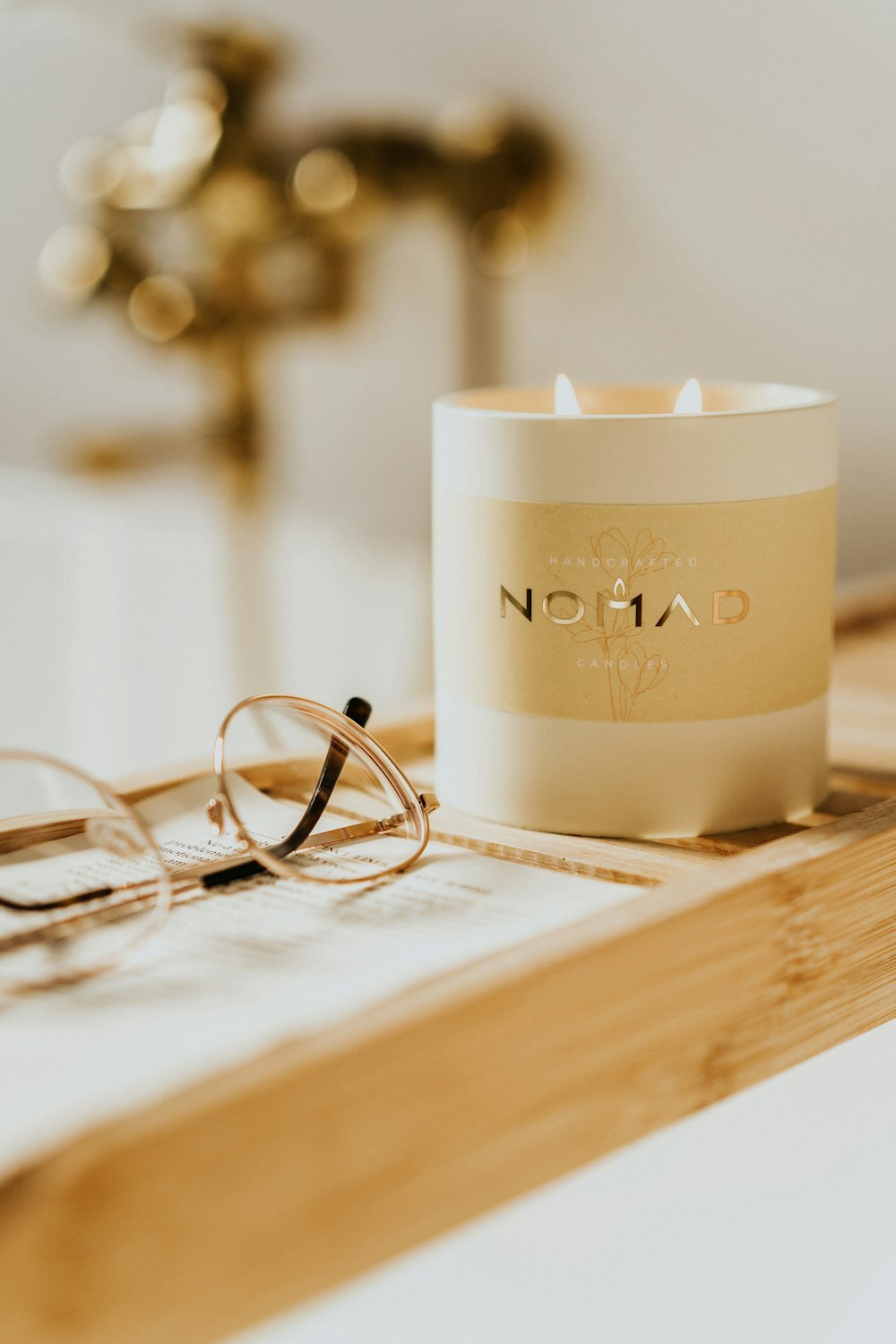 a pair of glasses sitting on top of a table next to a candle