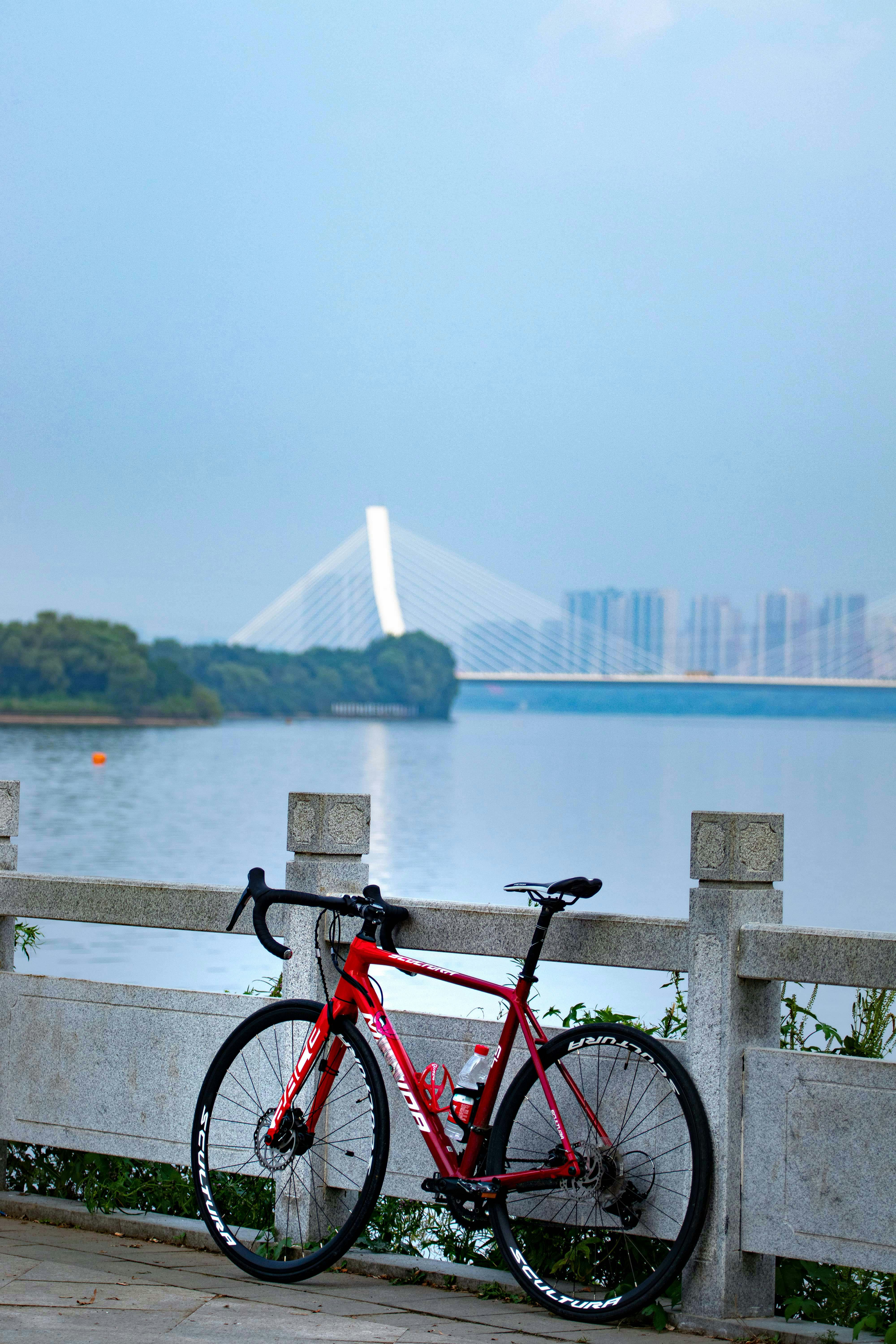 a red bike parked next to a wooden fence