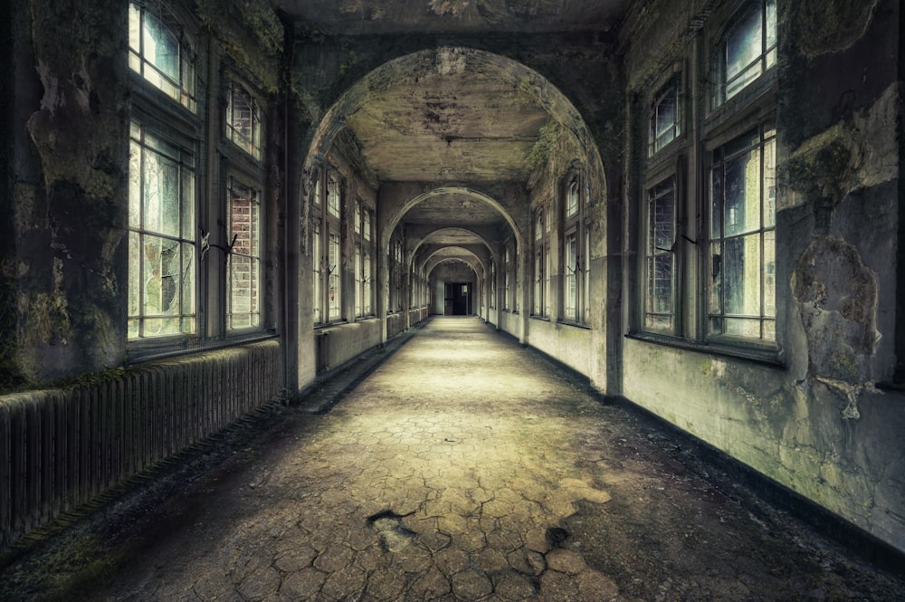 a long hallway with windows leading to another room