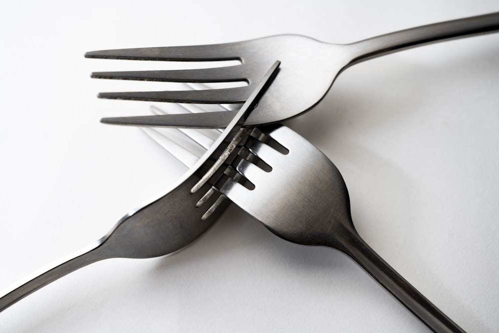 a fork and a knife on a white surface