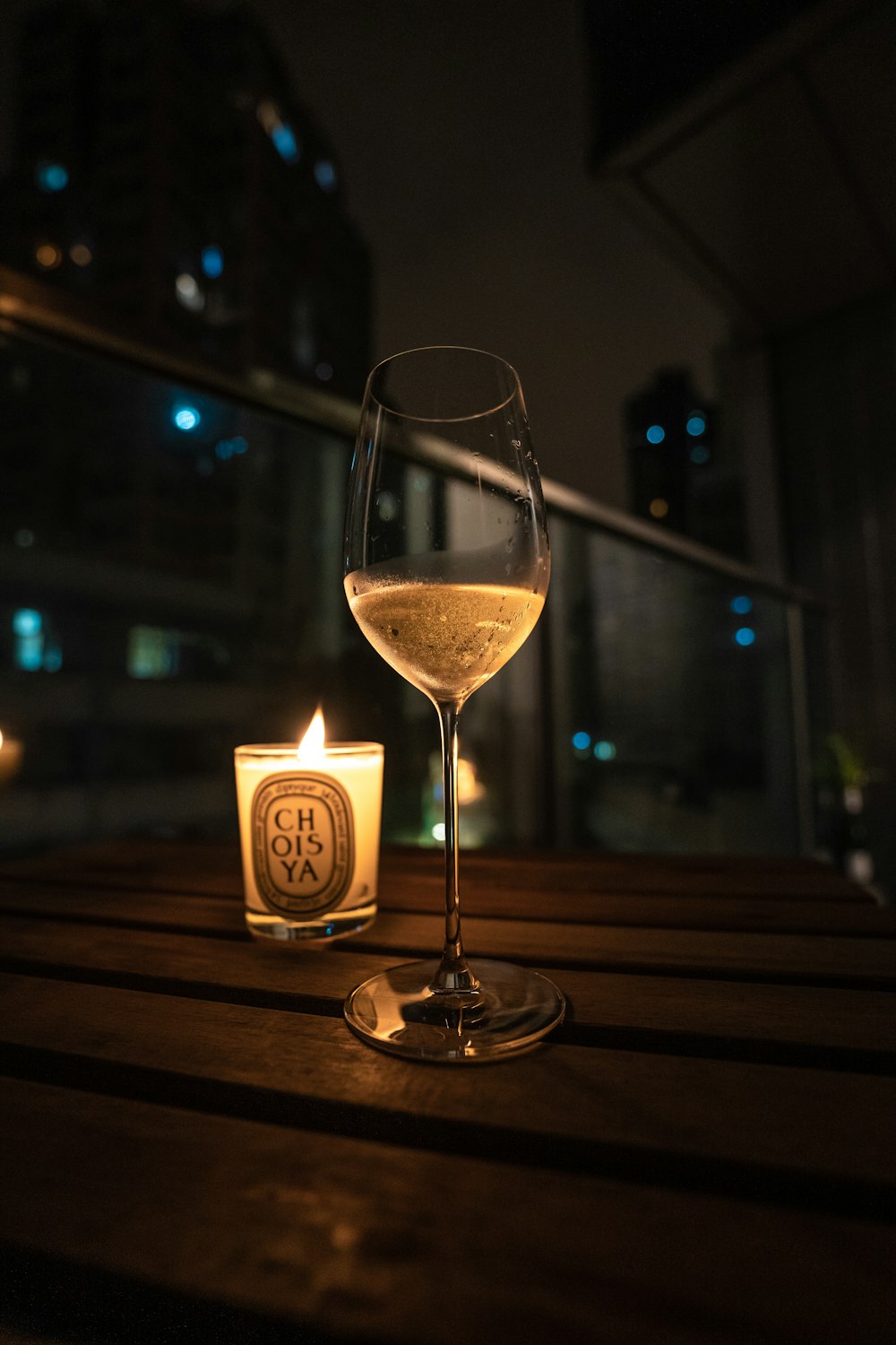 a candle and a glass of wine on a table