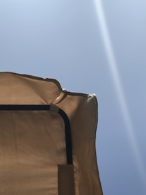 A sleek tensile structure with flowing fabric set against a bright sky.