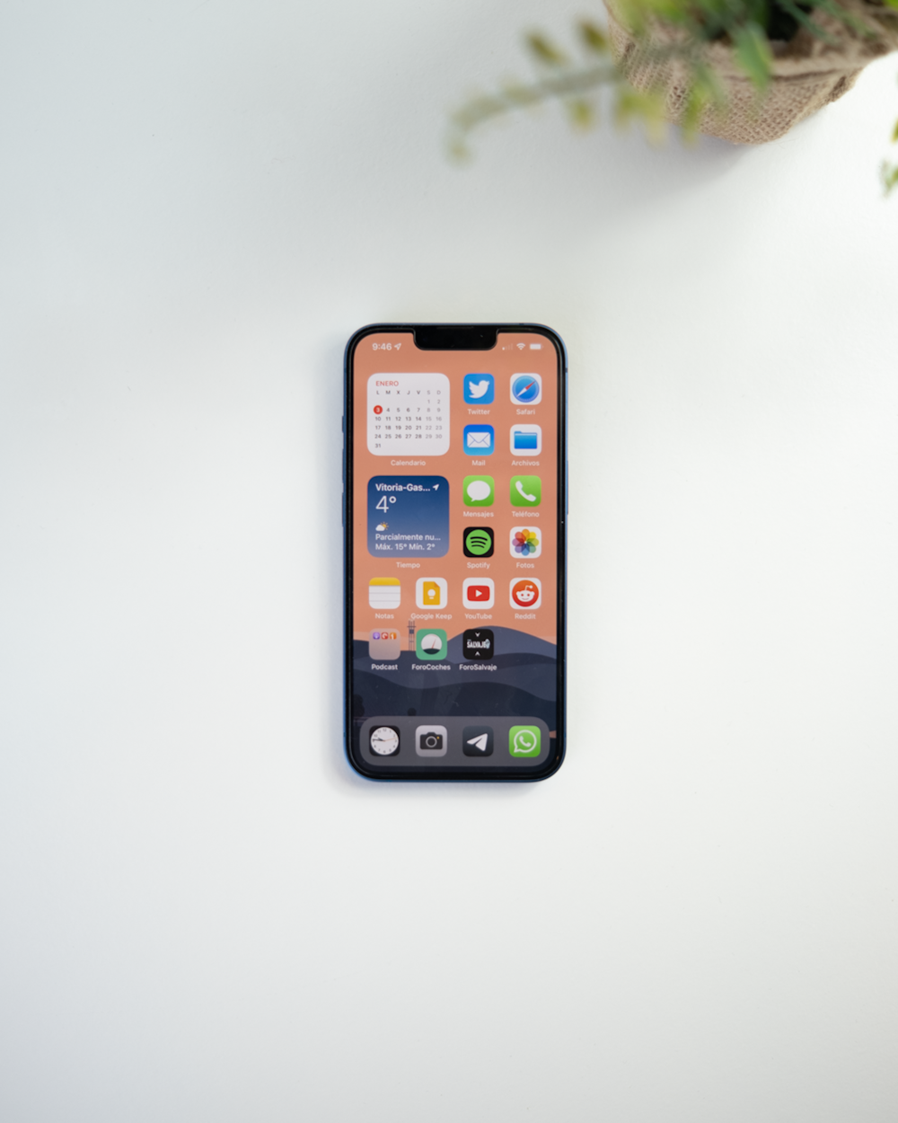 a cell phone sitting on top of a table next to a plant