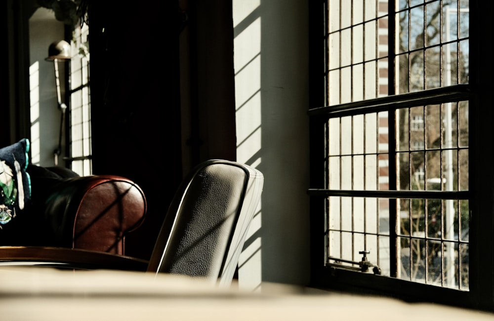 a chair sitting in front of a window next to a table