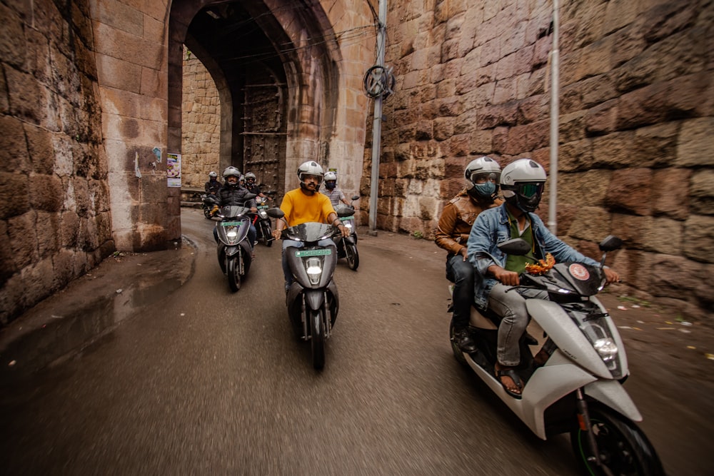 Un grupo de personas montando motocicletas por una calle