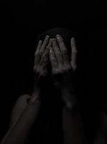 A hand holding a mask, symbolizing deception and hidden intentions.