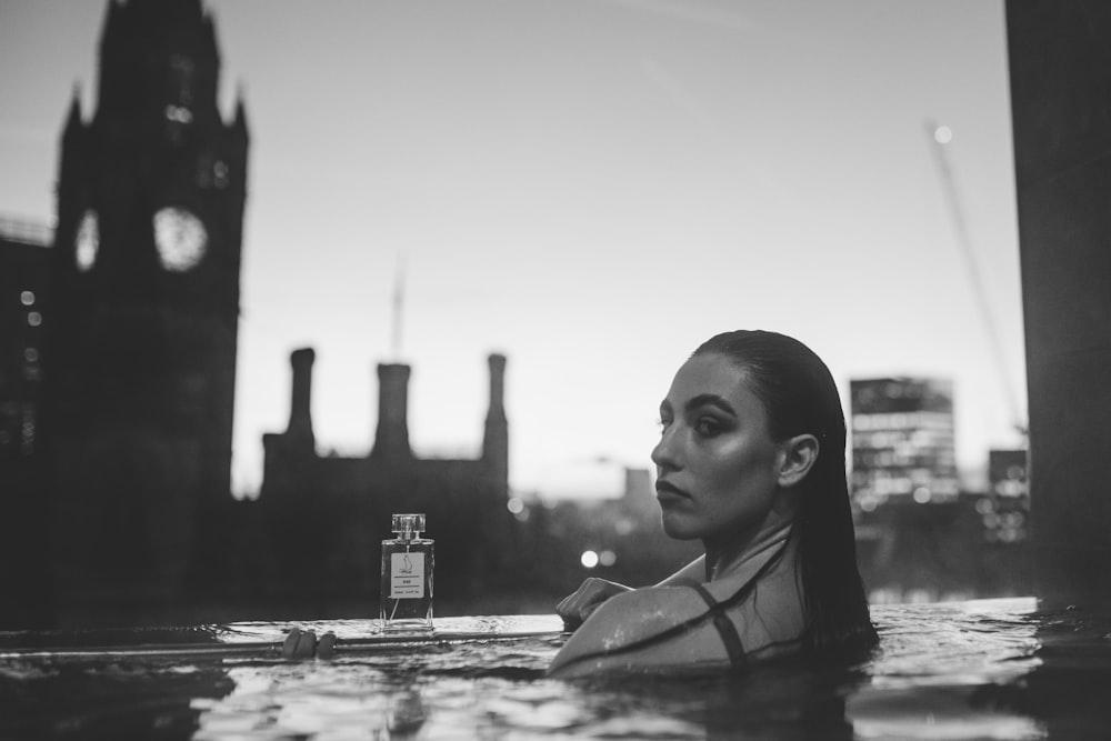 a woman in the water with a bottle of cologne