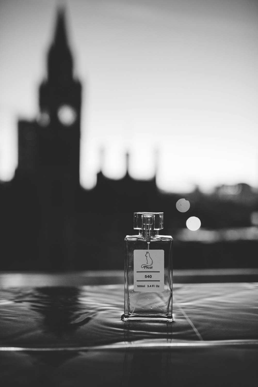 A bottle of perfume sitting on top of a table photo – Free White